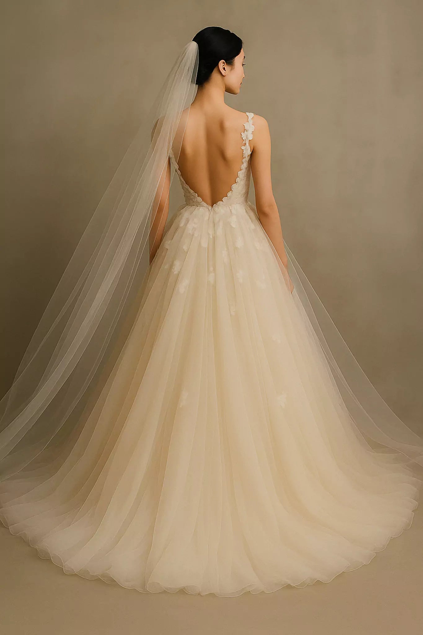 Back view of bridal gown with intricate lace detailing, chiffon skirt, and sleeveless V-neck, highlighting the elegant design and couture craftsmanship.